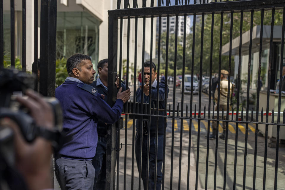 Private security guards close the gate of a building housing BBC office in New Delhi, India, Tuesday, Feb. 14, 2023. Officials from India's Income Tax department began conducting searches Tuesday at the BBC's offices in the capital, New Delhi, three of the broadcaster's staff members told the Associated Press. (AP Photo/Altaf Qadri)