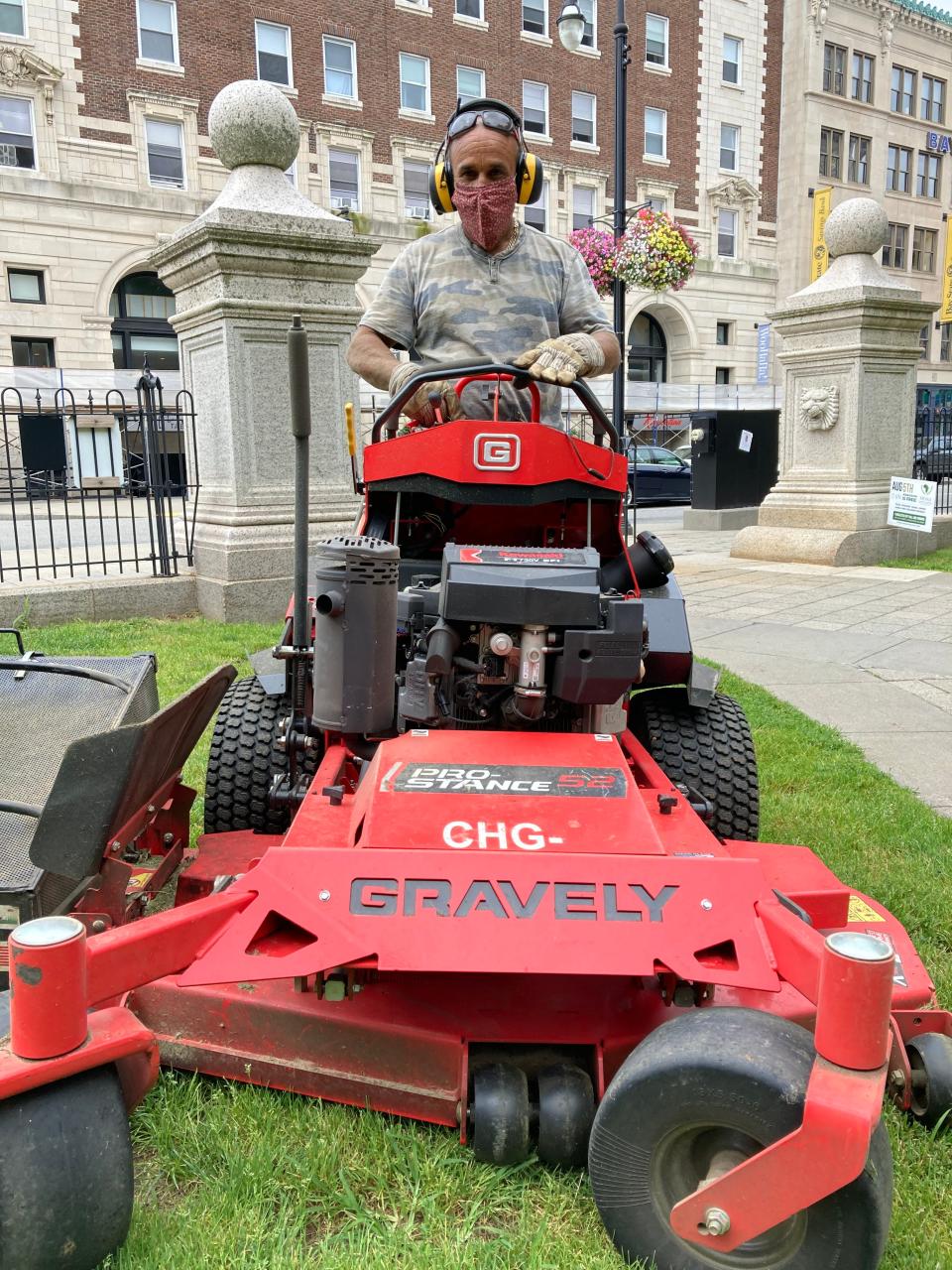 Hermes Rivera of the city parks department cuts grass on the Worcester Common Thursday with the city under a heat advisory and facing the possibility of severe thunderstorms.