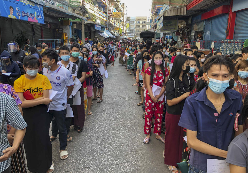 FILE - In this Dec. 20, 2020, file photo, People stand in lines to get COVID-19 tests in Samut Sakhon, South of Bangkok. Thailand, which has kept the coronavirus largely in check for most of the year, is facing a challenge from a large outbreak of the virus among migrant workers in the province close to Bangkok.(AP Photo/Jerry Harmer, File)