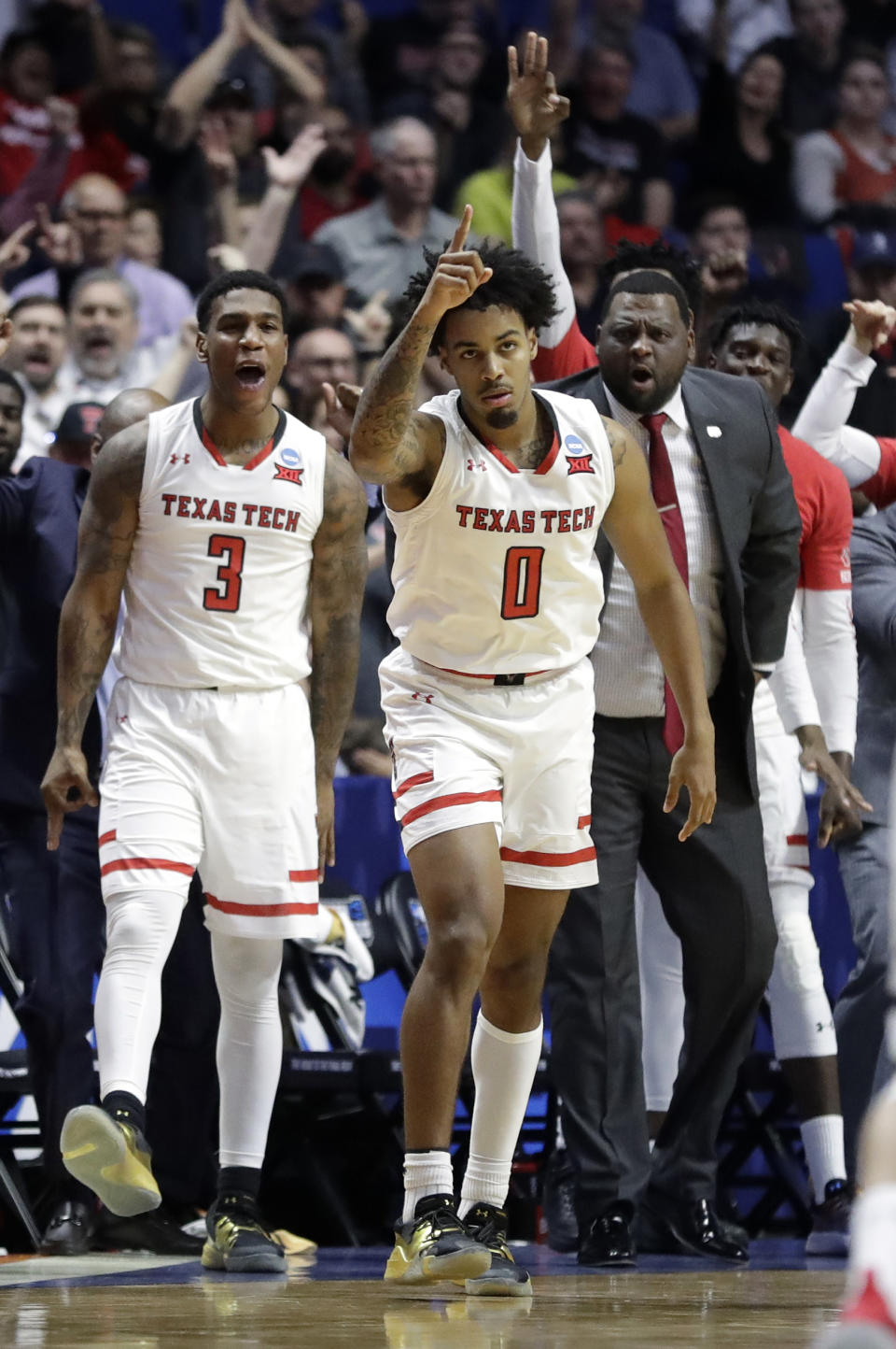 Texas Tech's Kyler Edwards (0) celebrates after making a 3-point basket as teammate Deshawn Corprew (3) cheers during the second half of a second round men's college basketball game against Buffalo in the NCAA Tournament Sunday, March 24, 2019, in Tulsa, Okla. (AP Photo/Jeff Roberson)