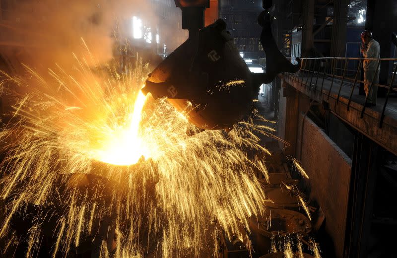 FILE PHOTO: An employee monitors molten iron being poured into a container at a steel plant in Hefei