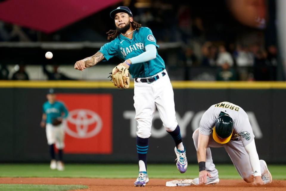 SEATTLE, WASHINGTON - SEPTEMBER 30: J.P. Crawford #3 of the Seattle Mariners turns a double play over Seth Brown #15 of the Oakland Athletics during the seventh inning at T-Mobile Park on September 30, 2022 in Seattle, Washington. (Photo by Steph Chambers/Getty Images)