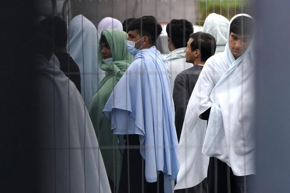 A view of people thought to be migrants inside the Manston immigration short-term holding facility located at the former Defence Fire Training and Development Centre in Thanet, England, Thursday, Nov. 3, 2022. Details about overcrowding and inhumane conditions at a migrant processing center in southeast England have shocked Britain and reignited a heated debate about how the Conservative government is handling a sharp increase in the number of asylum-seekers arriving on U.K. shores (Gareth Fuller/PA via AP)