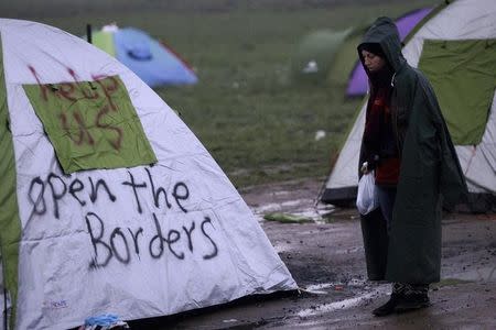 A refugee stands next to a tent at a relocation camp where stranded refugees and migrants wait to cross the Greek-Macedonian border, near the Greek village of Idomeni, March 1, 2016. REUTERS/Alexandros Avramidis