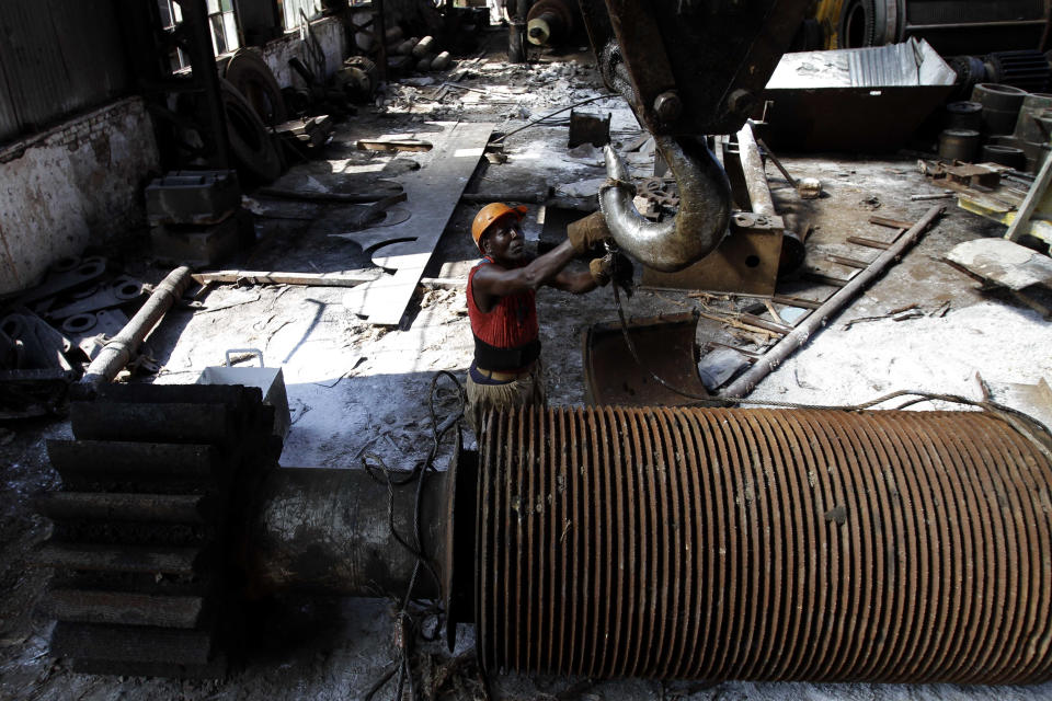 In this Sept. 8, 2012 photo, Jose Tabio, 56, repairs machinery at the sugar processing plant "Brasil" in Jaronu, Cuba. The Brasil sugar plant, launched in 1921, is getting a makeover and is expected to be ready in time for the upcoming annual harvest and start milling cane by February. (AP Photo/Franklin Reyes)