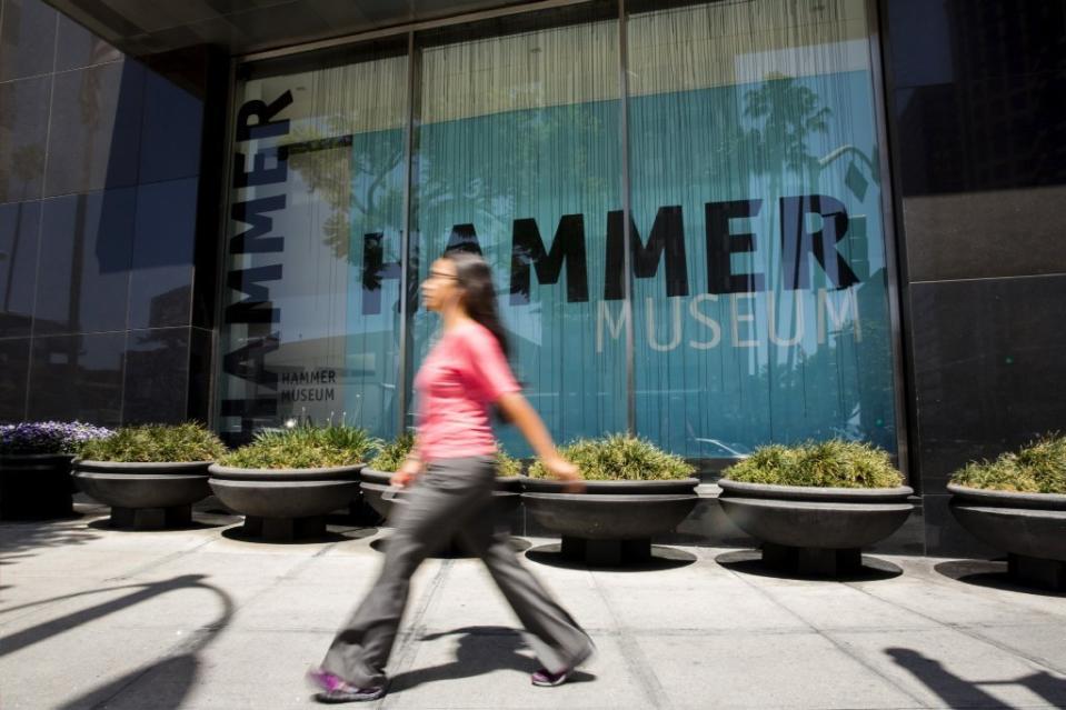 A pedestrian in a pink shirt walks past the Hammer Museum