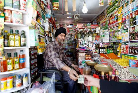 Afghan Sikh Jagtar Singh Laghmani, 50, accepts money from a customer at his traditional herb shop in Kabul, Afghanistan June 19, 2016. REUTERS/Mohammad Ismail