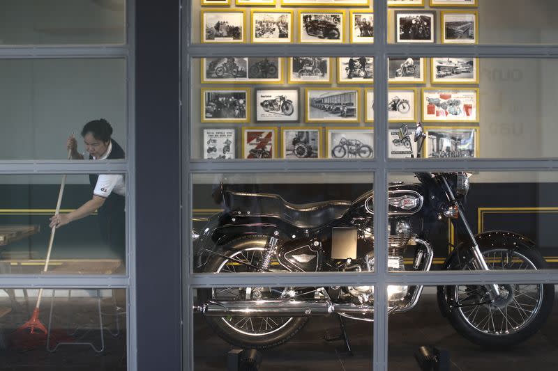 A worker cleans inside Royal Enfield's flagship shore in Bangkok