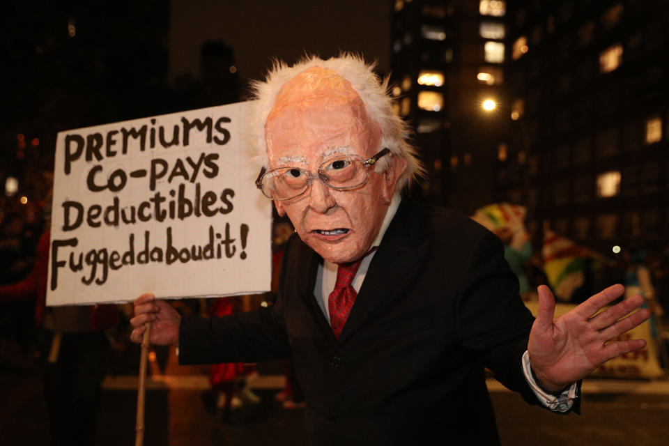 A man dressed as Bernie Sanders carrying a sign marches in the 46th annual Village Halloween Parade in New York City. (Gordon Donovan/Yahoo News)