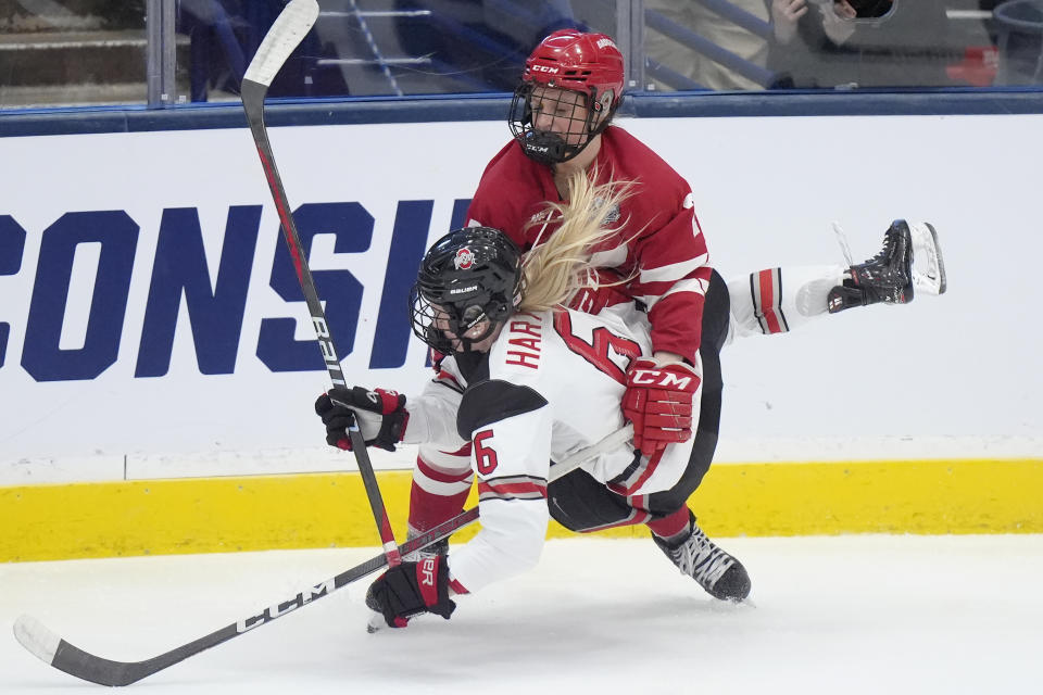 Ohio State defenseman Hadley Hartmetz (6) and Wisconsin forward Kirsten Simms (27) collide in the second period of an NCAA college women's championship hockey game, Sunday, March 24, 2024, in Durham, N.H. (AP Photo/Steven Senne)