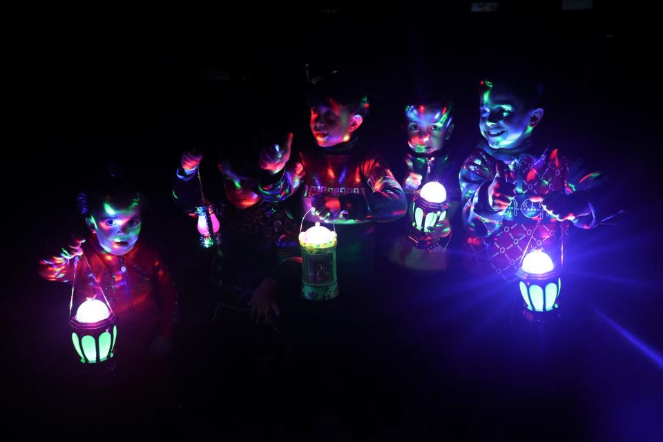 Palestinian children carry traditional "fanous" lanterns in Rafah, in the southern Gaza Strip, on the eve of the Muslim holy fasting month of Ramadan on March 10, 2024, amid ongoing battles between Israel and the Palestinian militant group Hamas.