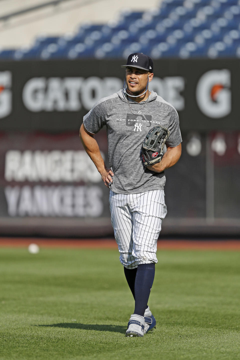 New York Yankees' Giancarlo Stanton, who has been out the much of the season with injuries and is still on the IL, stands in the outfield after a workout before the team's baseball game against the Texas Rangers, Wednesday, Sept. 4, 2019, in New York. (AP Photo/Kathy Willens)