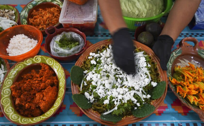 Un vendedor prepara un plato con nopales, cebolla y cilantro