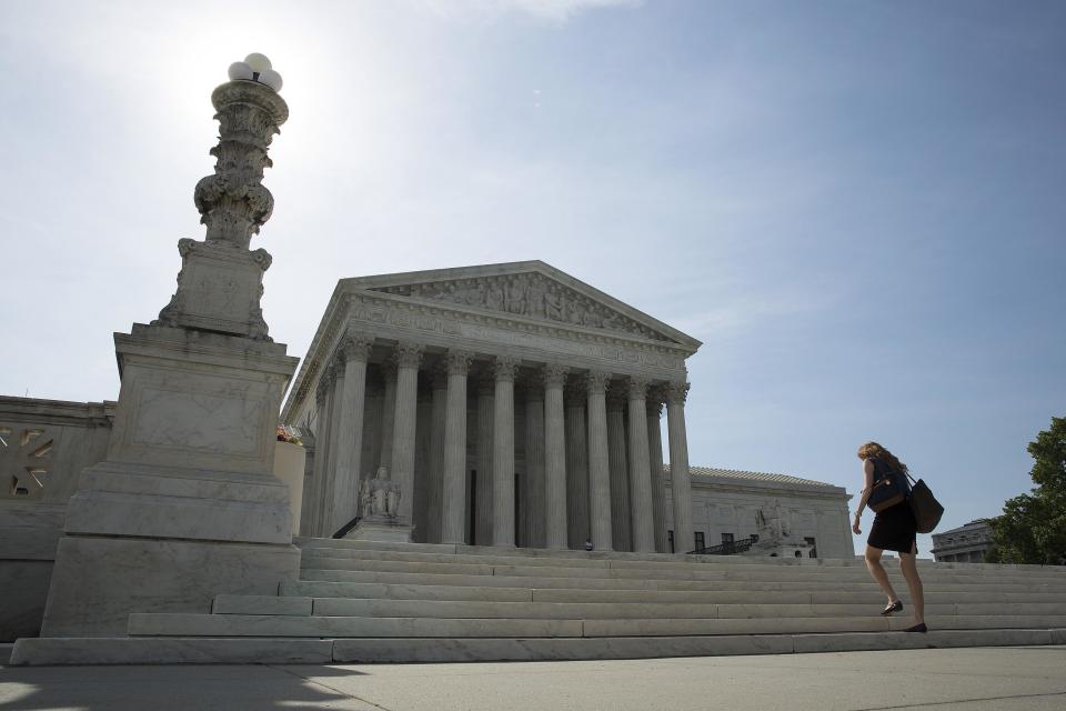 A woman walks to the Supreme Court in Washington in this June 19, 2014 file photo. Gay marriage may be the most anticipated issue heading for the U.S. Supreme Court, but the justices also must tackle a host of business cases as they convene for their new term, including a patent battle involving Teva Pharmaceutical Industries Ltd. REUTERS/Joshua Roberts/Files (UNITED STATES - Tags: POLITICS CRIME LAW)