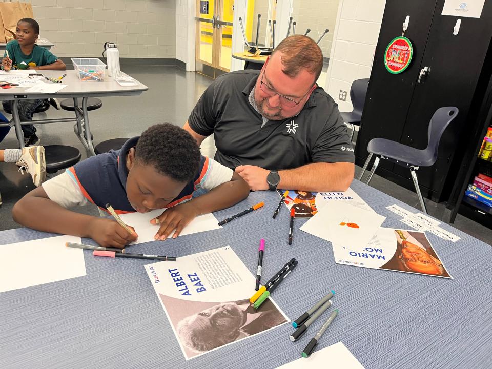 Adam Jones works on his offering for the first Hispanic Heritage Art Contest, sponsored by UScellular, at the Lonsdale location for the Boys & Girls Clubs of the Tennessee Valley. Haskell Vinson of UScellular looks on. Aug. 31, 2023