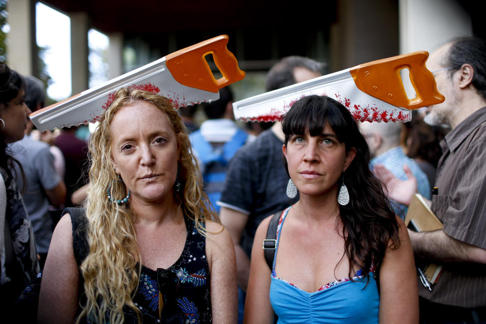 Scientific researchers Judith Naidorf and Marcela Kurlat pose for a photo as they protest government budget cuts outside the headquarters of the National Scientific and Technical Research Council, the main agency for science and technology, in Buenos Aires, Argentina, Wednesday, April 10, 2019. As part of the austerity measures aimed at balancing the budget, the government laid off thousands of government workers and slashed funding for science. (AP Photo/Natacha Pisarenko)