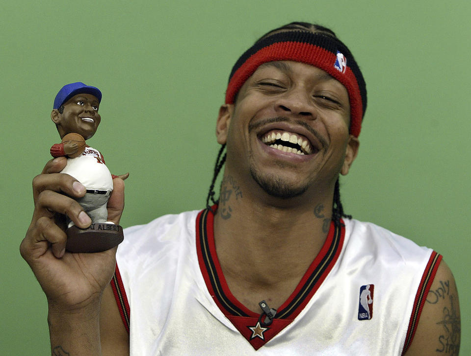 FILE - Philadelphia 76ers' Allen Iverson laughs with a promotional "Fat Albert" Bobble Head doll, Oct. 4, 2004. Just as a movie soundtrack helps viewers follow the action of the narrative through each plot twist, hip-hop has done the same for basketball via the NBA. A legacy was passed to Iverson when he entered the NBA in 1996, embodying hip-hop culture in everything he did, from his clothes to his corn rows. (Steven M. Falk/The Philadelphia Inquirer via AP, file)