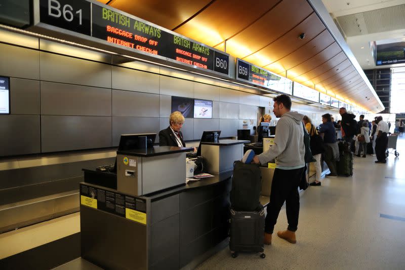 People check in to a British Airways flight at the international terminal at LAX airport in Los Angeles