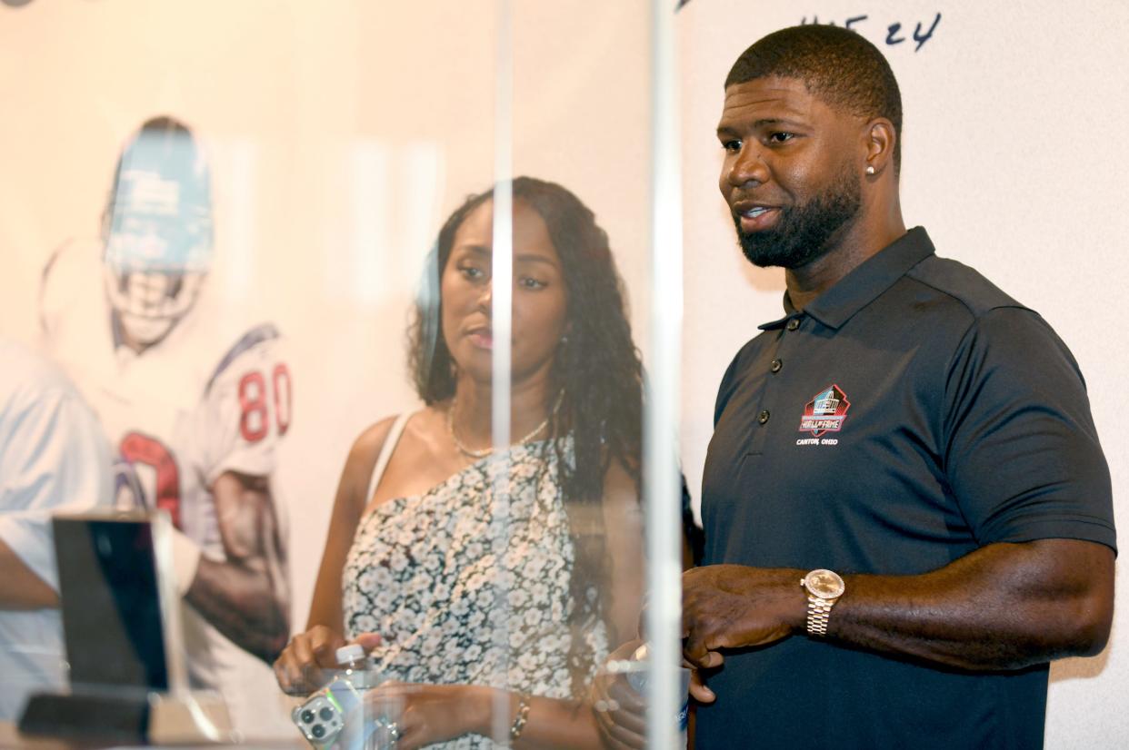 Devin Hester, a member of the Pro Football Hall of Fame Class of 2024, with his wife Zingha, look at a case of his memorabilia during a visit to the Hall, Friday, May 24, 2024.