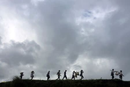 FILE PHOTO: People displaced by violence walk in the banks of Mayu river with their belongings while moving to another village, in Buthidaung in the north of Rakhine state, Myanmar September 13, 2017. Picture taken September 13, 2017. REUTERS/Stringer