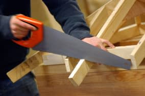 British carpenter sawing timber frame construction London UK