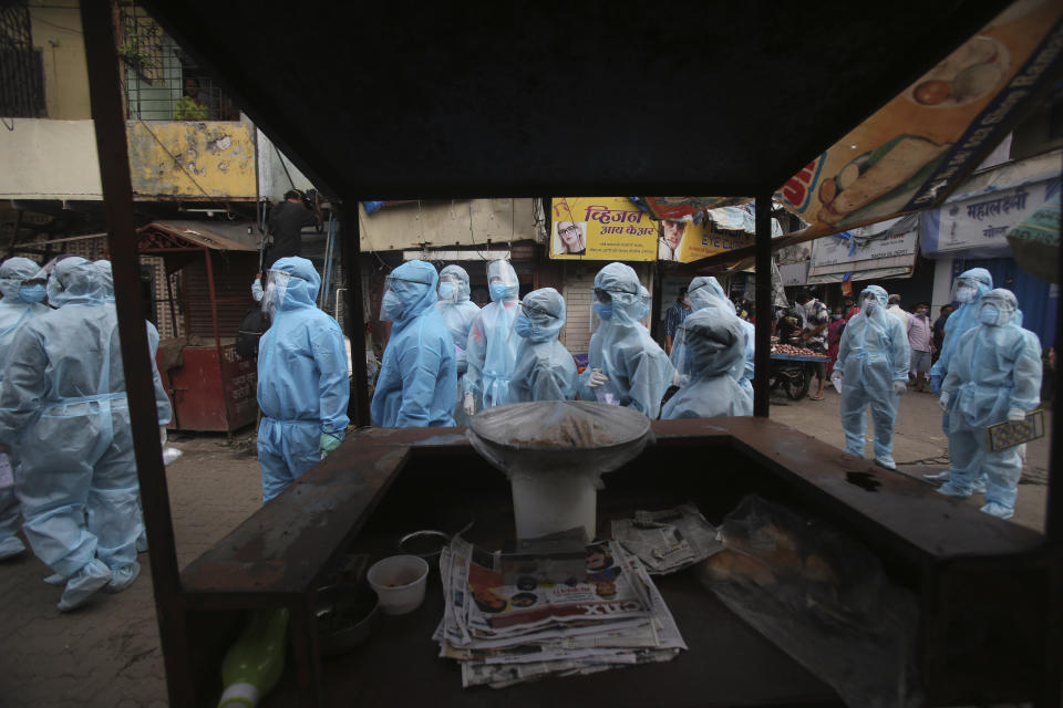 India health workers wearing personal protective equipment arrive to take part in a check up camp at a slum in Mumbai, India, Wednesday, June 17, 2020. India is the fourth hardest-hit country by the COVID-19 pandemic in the world after the U.S., Russia and Brazil. (AP Photo/Rafiq Maqbool)