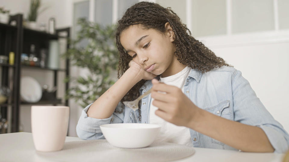 Girls looks at bowl of food as study finds that three in 10 young women suffer from an eating disorder