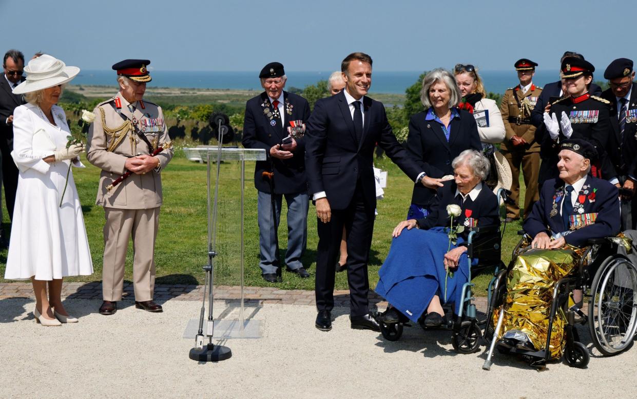 President Macron awards Christian Lamb with the insignia of Knight in the Legion of Honour order, as the King and Queen look on