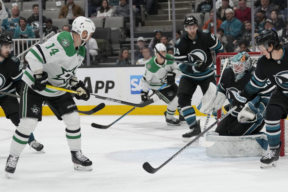 Dallas Stars left wing Jamie Benn (14) scores a goal against San Jose Sharks goaltender Mackenzie Blackwood, second from right, during the second period of an NHL hockey game in San Jose, Calif., Tuesday, March 26, 2024. (AP Photo/Jeff Chiu)
