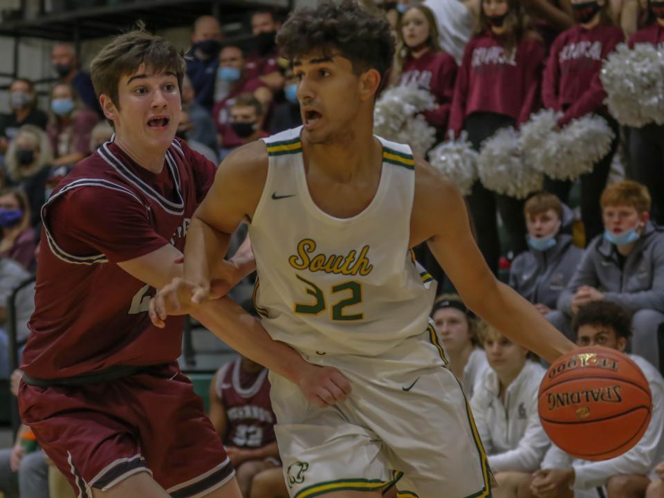 Salina South's Edgar Garcia (32) dribbles around Salina Central's Dylan Drane (24) during Friday's game at the South gym.