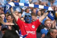 A Wigan Athletic fan shows his support in the stands