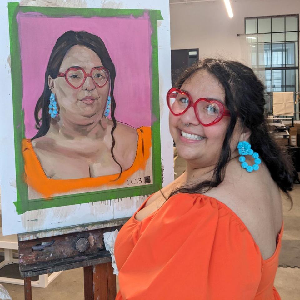 Samantha Figueroa beams as she stands next to her portrait. Rusty Zimmerman