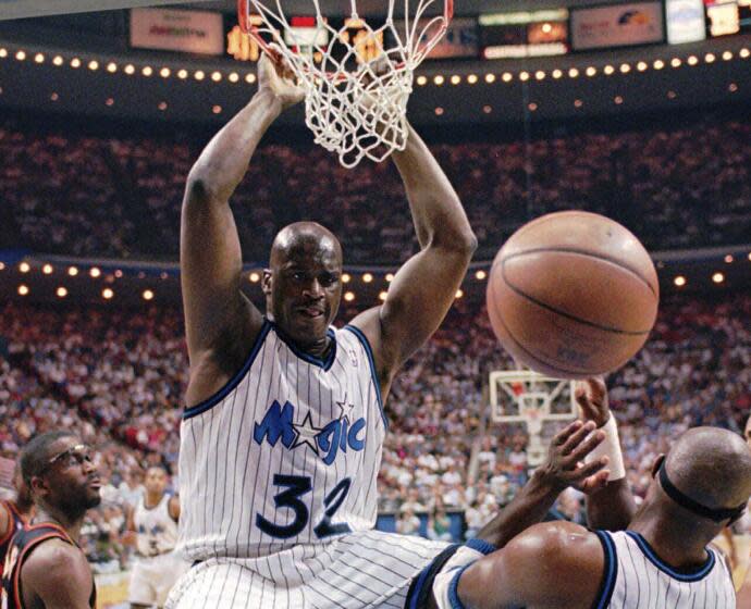 Orlando Magic center Shaquille O'Neal (32) hangs from the rim after a slam-dunk