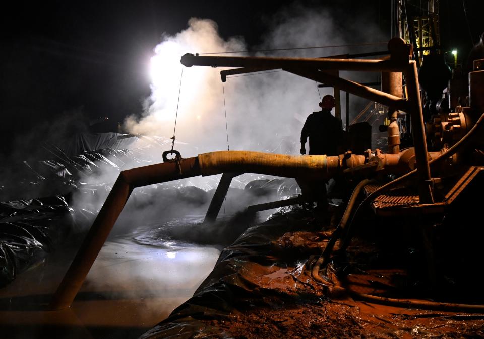 An oil rig worker monitors water expelled into one of the pits at an Abilene drill site in the 2400 block of Burger St. Jan. 3. The derrick was erected during the holiday break in the corner lot bordering Vogel Ave. across from Town & Country Drive-In and Ortiz Elementary School and shut down before students returned.