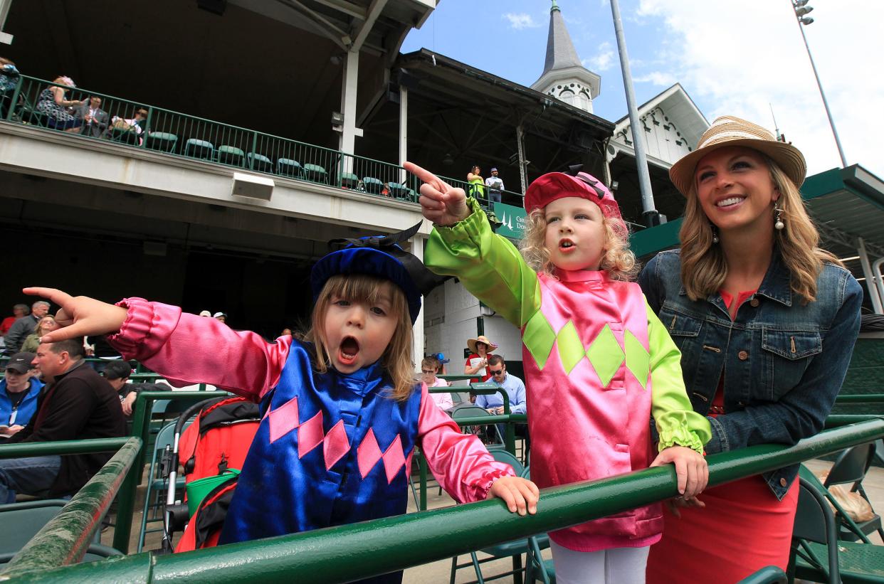 Teagan Oliver, 2, and Paisley Oliver, 3, point and yell to their mom, Hannah, as they spot horses heading to the paddock at Churchill Downs as part of Thurby.April 30, 2015