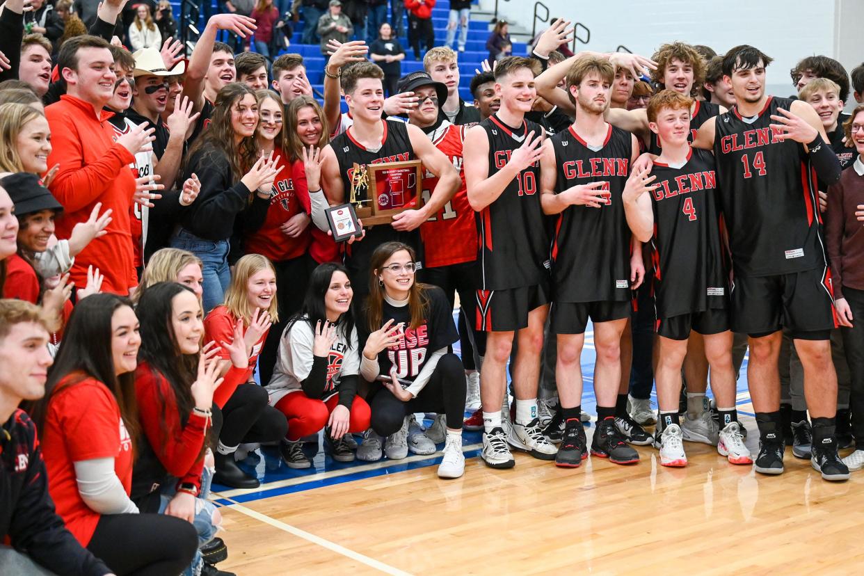 The John Glenn Falcons pose for photos with fans after defeating Triton 52-35 in the TCU Bi-County Boys Varsity Finals Saturday, Jan. 22, 2022, at LaVille High School.