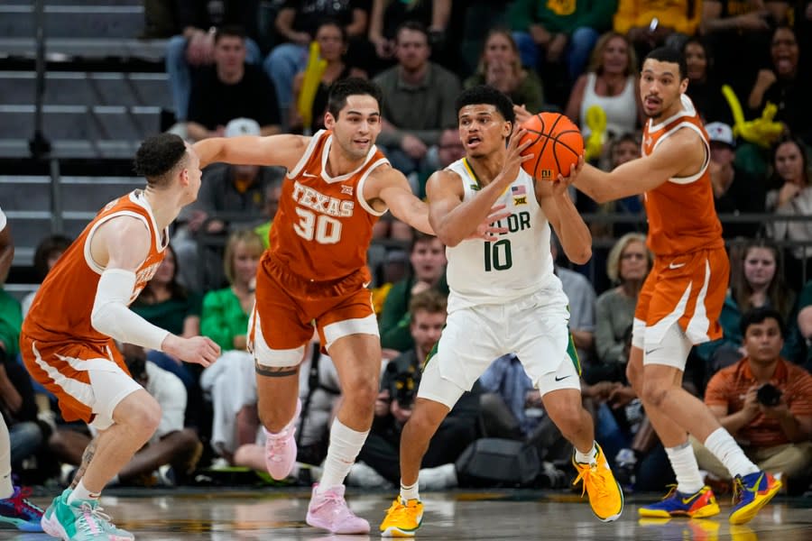 Baylor’s RayJ Dennis (10) collects a rebound against Texas’s Chendall Weaver, left, Brock Cunningham (30) and Dylan Disu (1) during the first half of an NCAA college basketball game, Monday, March 4, 2024, in Waco, Texas. (AP Photo/Julio Cortez)