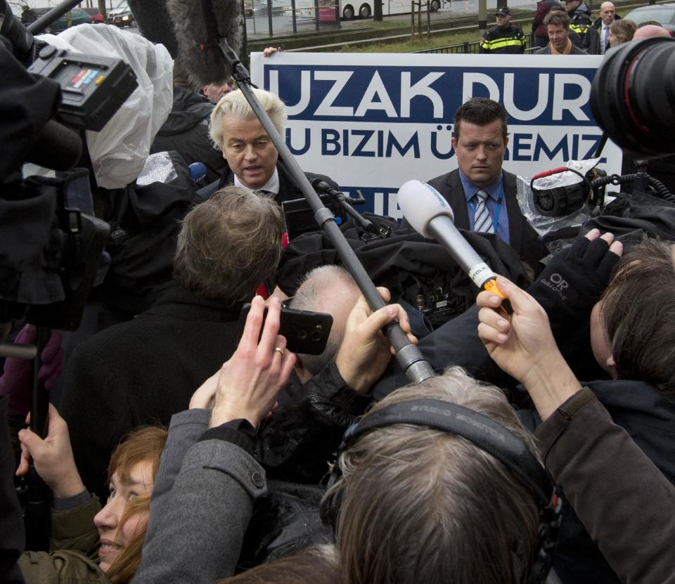 Campaign staff hold a banner reading "Stay Away, This Is Our Country" as firebrand anti Islam lawmaker Geert Wilders, left, protests outside the Turkish embassy in The Hague, Netherlands, Wednesday, March 8, 2017, against the planned campaign visit of Turkish Foreign Minister Mevlut Cavusoglu to lobby for a referendum giving President Erdogan increased powers. (AP Photo/Peter Dejong)