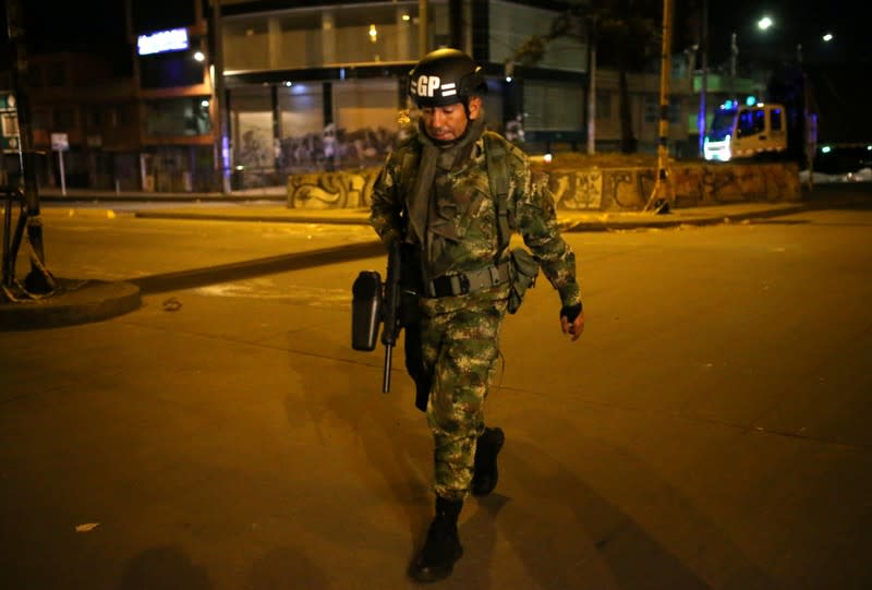 Un efectivo del ejército patrulla una calle durante el toque de queda decretado después de los disturbios en Bogotá