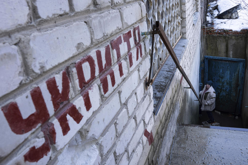 Valentyna Mozgova, 55, a lab medic walks down stairs to a shelter at a hospital which was damaged by Russian shelling in Krasnohorivka, Ukraine, Sunday, Feb. 19, 2023. (AP Photo/Evgeniy Maloletka)