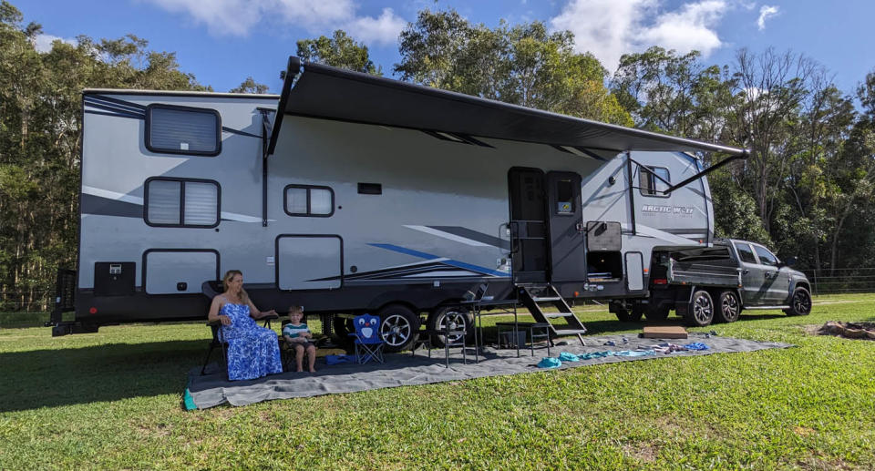 Michelle Crysell and son sitting in front of US imported caravan while travelling. 