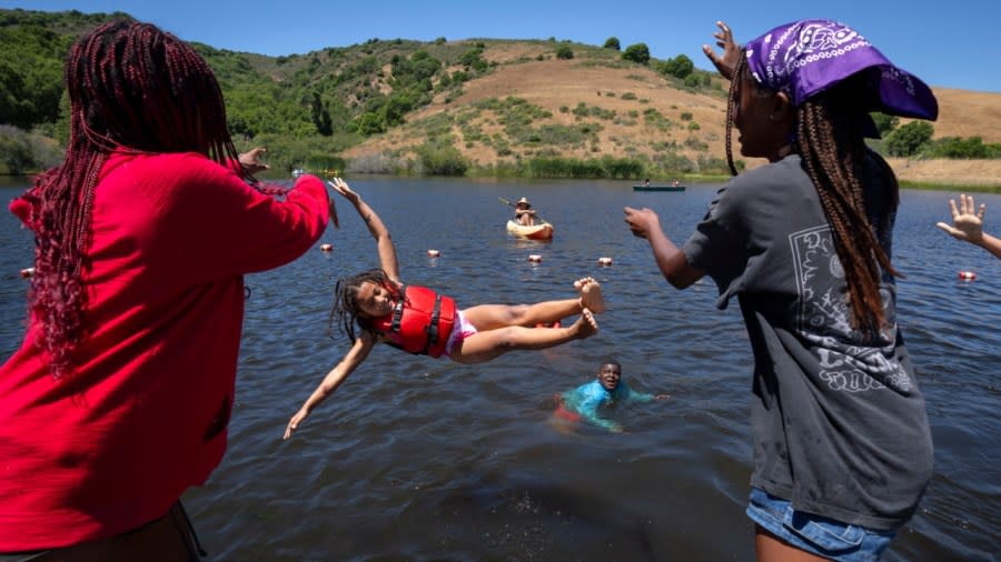 Maya Johnson, 7, of New York, is playfully swung into the lake by her friends during Camp Be’chol Lashon, a sleepaway camp for Jewish children of color, late last month at Walker Creek Ranch in Petaluma, California. (Photo: Jacquelyn Martin/AP)