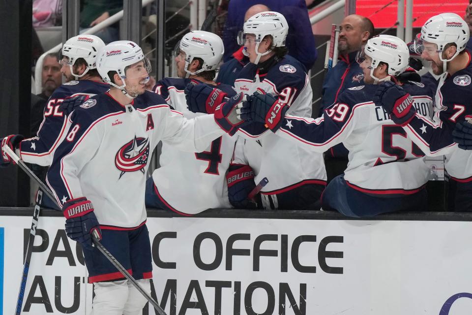 Columbus Blue Jackets defenseman Zach Werenski (8) is congratulated by teammates for his goal against the San Jose Sharks during the first period of an NHL hockey game in San Jose, Calif., Saturday, Feb. 17, 2024. (AP Photo/Jeff Chiu)