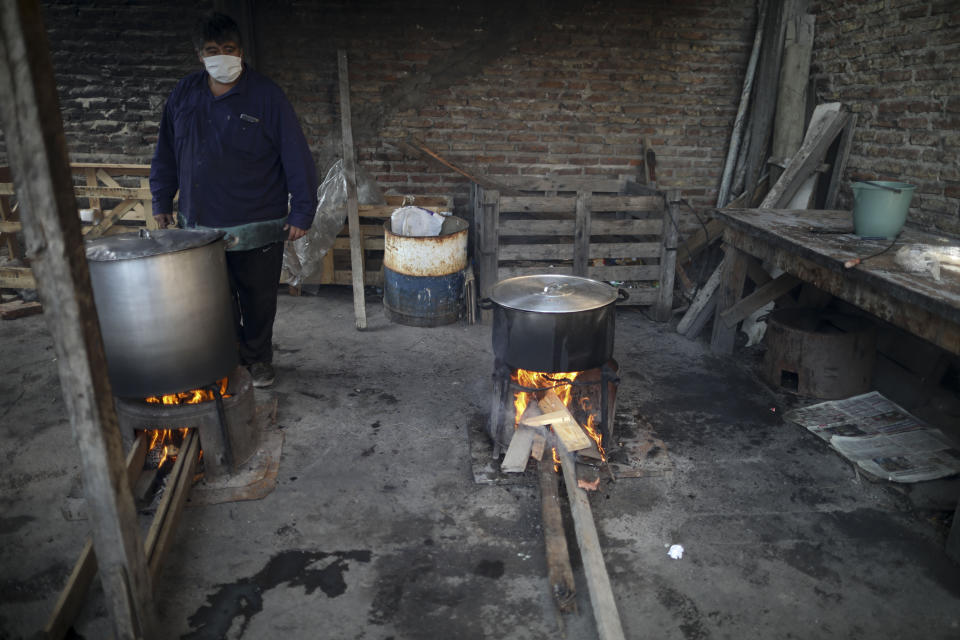 En esta imagen, tomada el 9 de junio de 2020, un voluntario vigila ollas al fuego en un comedor benéfico, durante la pandemia del coronavirus, a las afueras de Buenos Aires, Argentina. Argentina, uno de los mayores productores de alimentos del mundo, sufre además una creciente emergencia alimentaria. Daniel Arroyo, ministro de Desarrollo Social, dice a la AP que antes de la pandemia 8 millones de personas recibían alimentos, “y hoy tenemos 11 millones”. (AP Foto/Natacha Pisarenko)