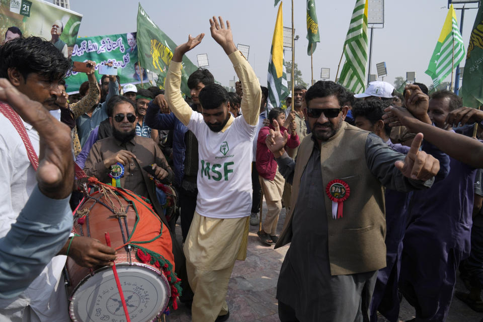 Supporters of Pakistan's former Prime Minister Nawaz Sharif dance on a traditional drum beat as they arrive to attend a welcoming rally for their leader, in Lahore, Pakistan, Saturday, Oct. 21, 2023. Sharif was returning home Saturday on a special flight from Dubai, ending four years of self-imposed exile in London as he seeks to win the support of voters ahead of parliamentary elections due in January. (AP Photo/K.M. Chaudary)