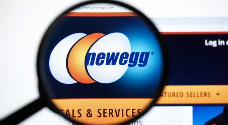 A magnifying glass zooms in on the website for Newegg (NEGG)