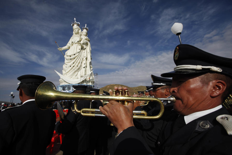 Musicians play during the unveiling of the Virgin Mary holding a baby Jesus on Santa Barbara hill in the mining city of Oruro, Bolivia, Friday, Feb. 1, 2013. The statue, known in Spanish as "Virgen del Socavón," or the Virgin of the Tunnel, is Oruro's patron, venerated in particular by miners and folkloric Carnival dancers. The statue was unveiled on Friday to mark the start of Carnival in Oruro, which coincides with celebrations honoring the Virgin that starts on Saturday, Bolivia's largest religious event. The city's carnival dates back to pre-Hispanic times, but it was during the colonial period that it became well known when, as legend has it, the image of the Virgin Mary revealed herself to a devotee who had been mortally wounded in a street fight. (AP Photo/Juan Karita)