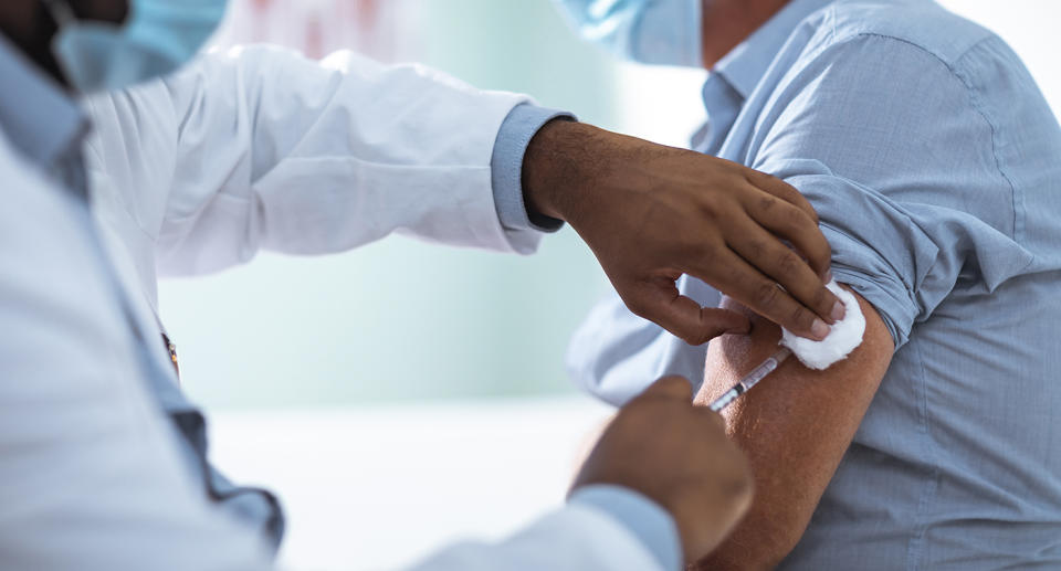 Close up of a mature man taking a vaccine in his doctors office