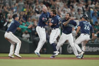 Seattle Mariners' Luis Torrens, center, is greeted by teammates Sam Haggerty, left, Mitch Haniger, second from left, Adam Frazier (26) and J.P. Crawford, second from right, after Torrens hit a walk-off RBI single to give the Mariners a 1-0 win over the New York Yankees in a 13-inning baseball game, Tuesday, Aug. 9, 2022, in Seattle. (AP Photo/Ted S. Warren)