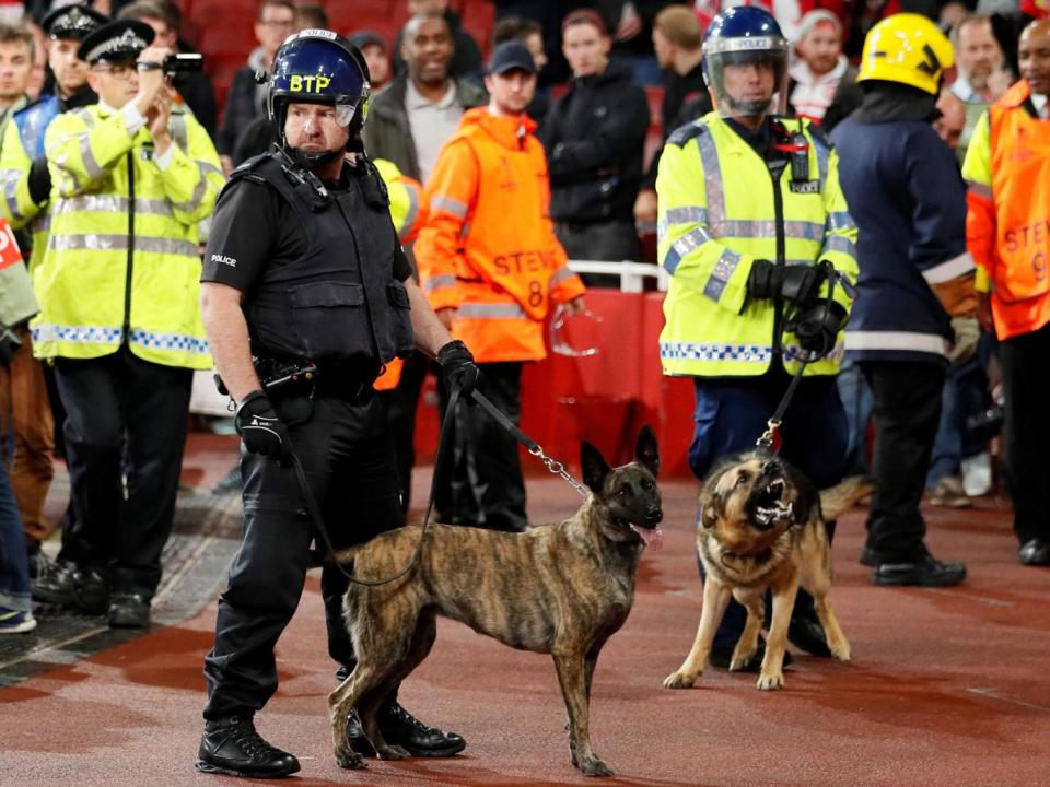 Police with dogs in front of Koln fans inside the Emirates stadium (Reuters)